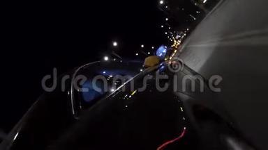 快速黑色汽车在夜间行驶道路穿过城市，从车轮上看，时间推移。 录像。 现代交通工具